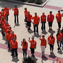 midland employees standing in heart in Midland orange shirts