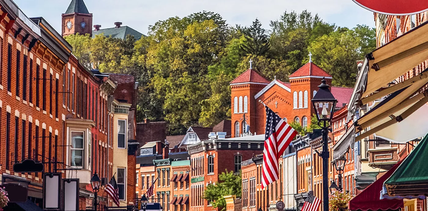 Small town street lined with brick buildings and American flags