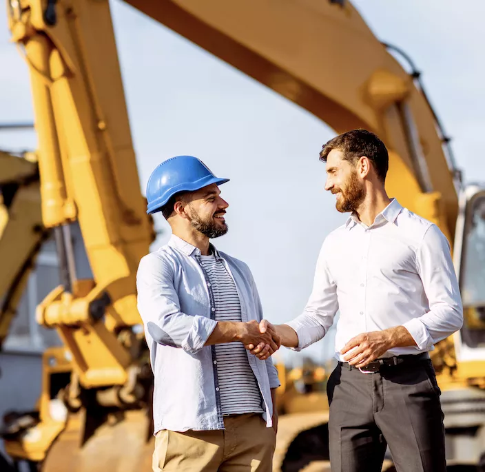 construction worker and equipment financing employee shaking hands
