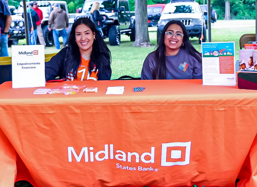 midland employees smiling while sitting at midland event table