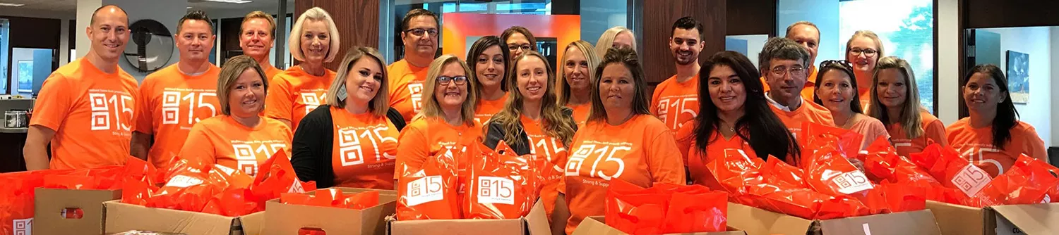 rockford team standing in lobby smiling while in orange Midland shirts
