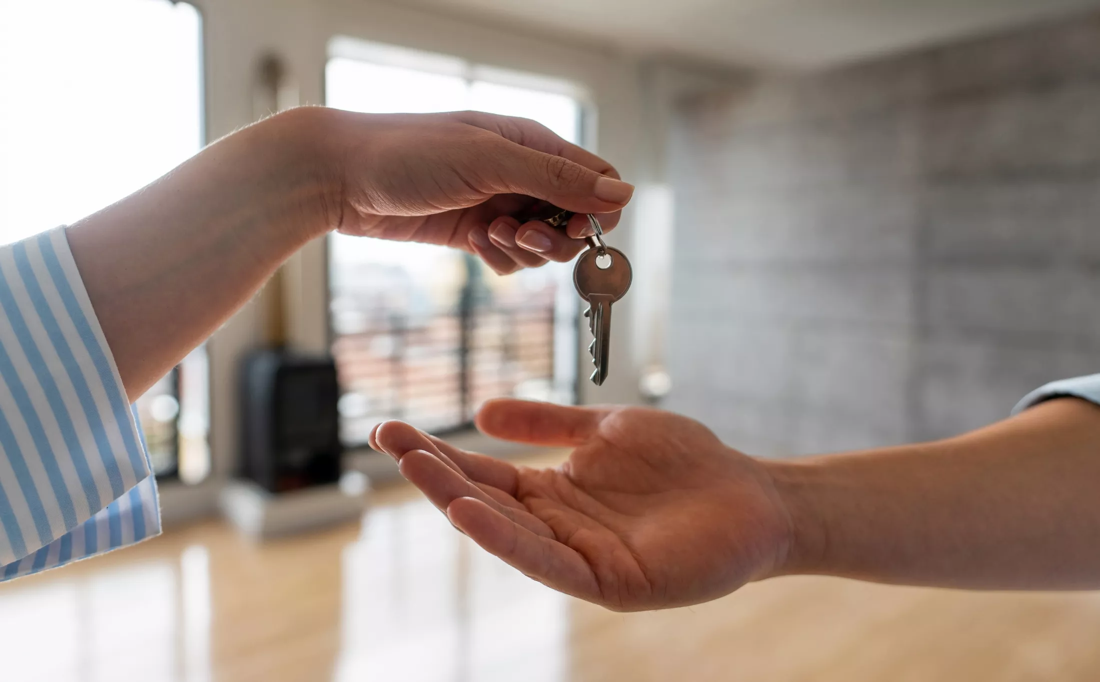 close up of someone handing house keys over to another person